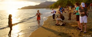 Students of the Cuba photo workshop take shots of a local woman on a beach.